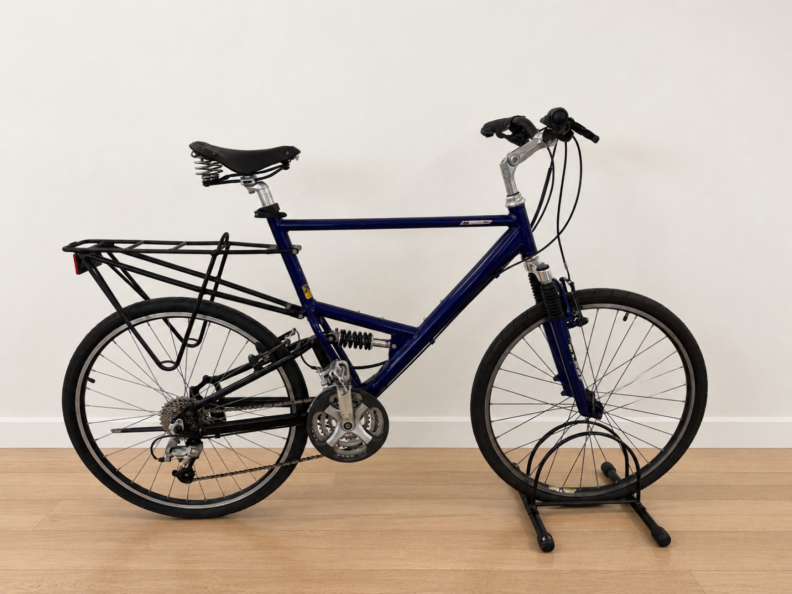 Bicicletta con telaio blu scuro, forcella ammortizzata e sospensione posteriore. 2