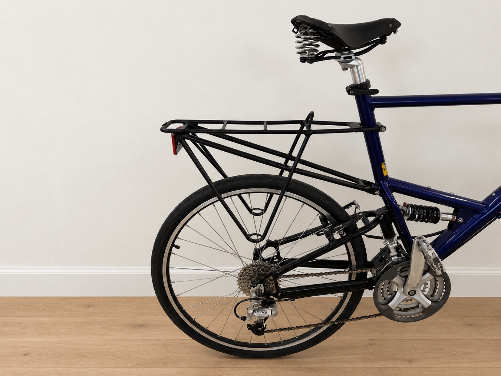 Bicicletta con telaio blu scuro, forcella ammortizzata e sospensione posteriore. 4