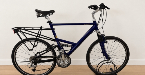 Bicicletta con telaio blu scuro, forcella ammortizzata e sospensione posteriore.